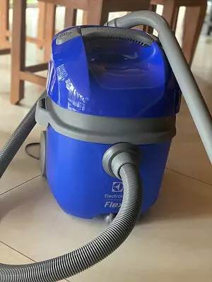 Electrolux FLEXN desligado em piso de cozinha com a mangueira acoplada