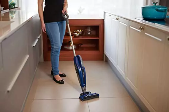 Mulher usando o Acqua MOB 2 para limpar piso de cozinha marrom