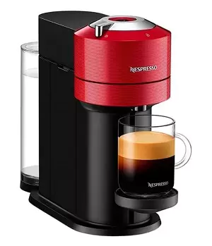 Cafeteira de cápsula Nespresso Vertuo Next, com corpo preto e painel redondo vermelho, com xícara grande apoiada.