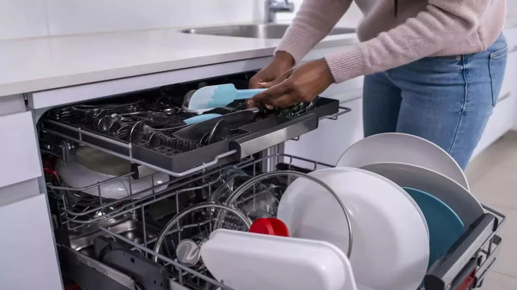 Abertura do post sobre como usar lava louças: Mulher colocando pratos em lava louças