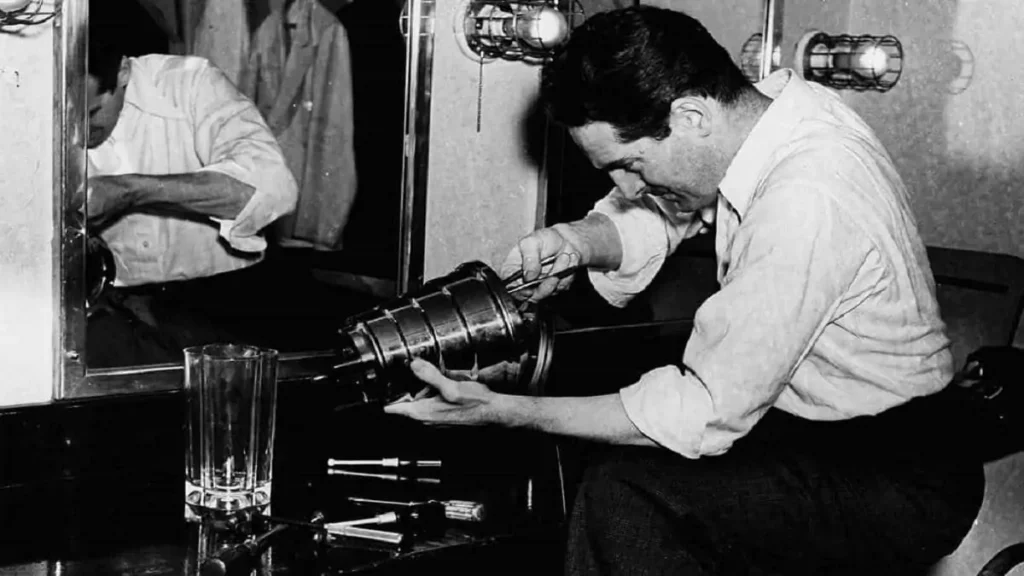 Imagem antiga mostrando homem fazendo manutenção em liquidificador