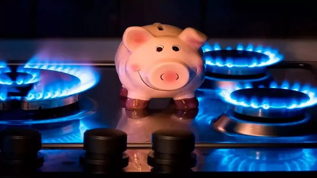 Abertura do post sobre como economizar gás de cozinha: Cofre de porquinho entre queimadores acesos