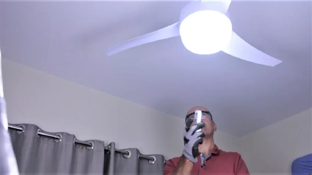 Abertura do post sobre porque o ventilador de teto não funciona: Homem fazendo manutenção em ventilador de teto