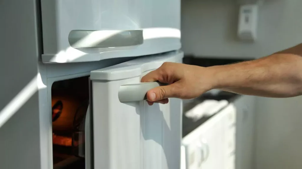 Abertura do post sobre como economizar energia com a Geladeira: Homem abrindo porta de geladeira