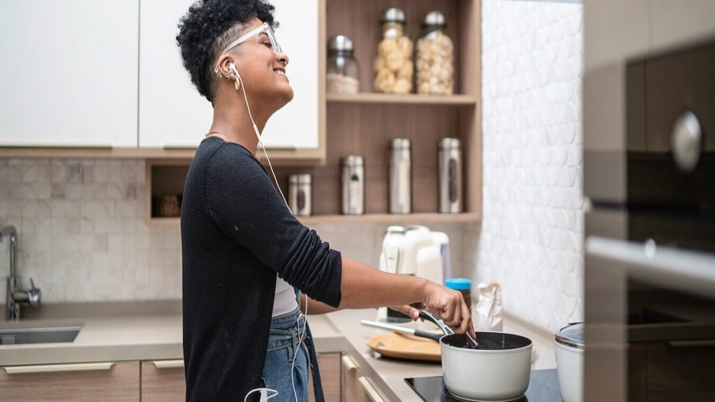 Imagem de abertura sobre o post de como escolher cooktop: Mulher cozinhando em cooktop