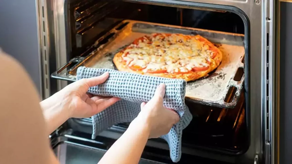 Abertura do post sobre como usar Forno Elétrico: Mulher inserindo pizza em forno